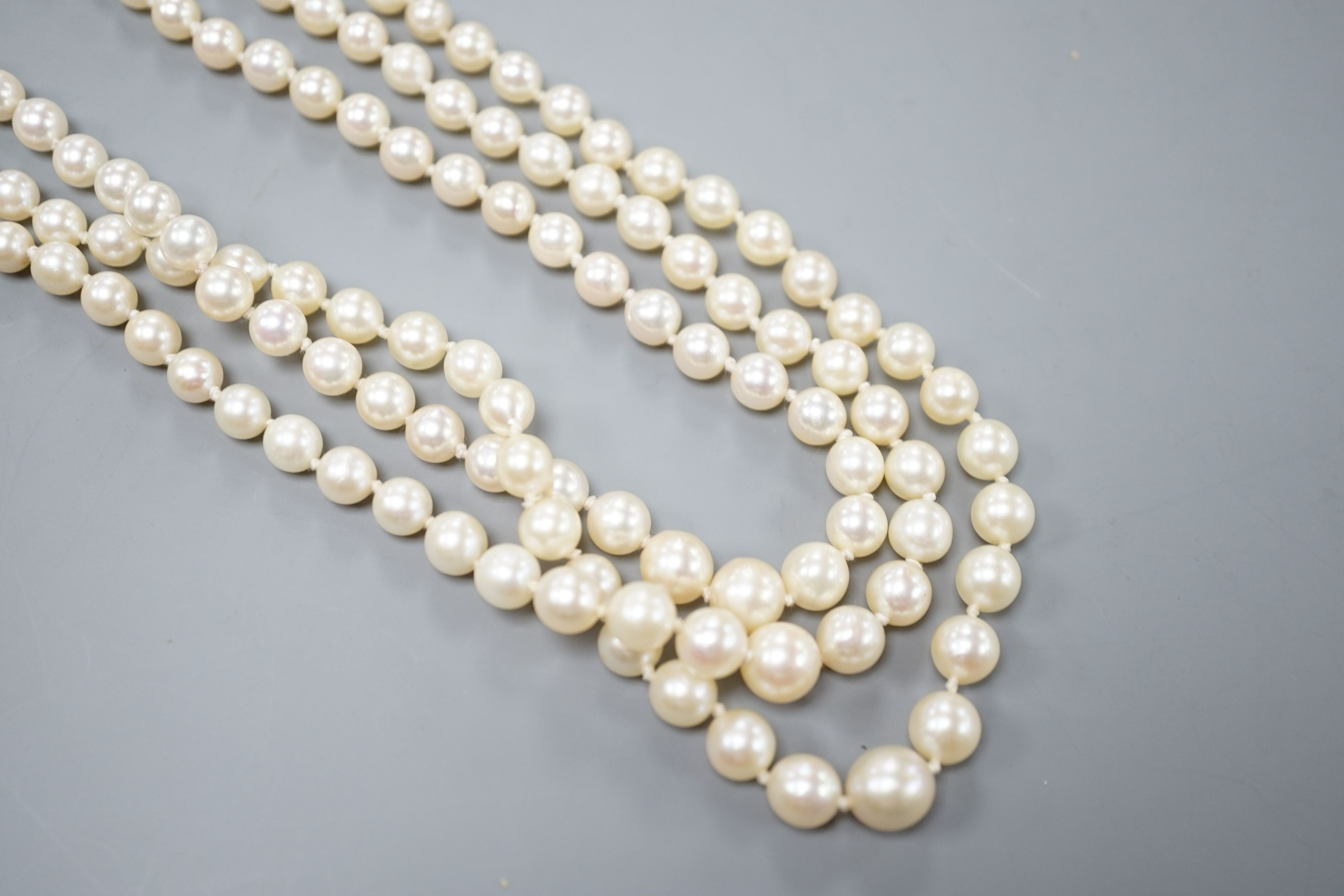 A modern triple strand graduated cultured pearl choker necklace, with diamond chip set white metal clasp, 38cm.